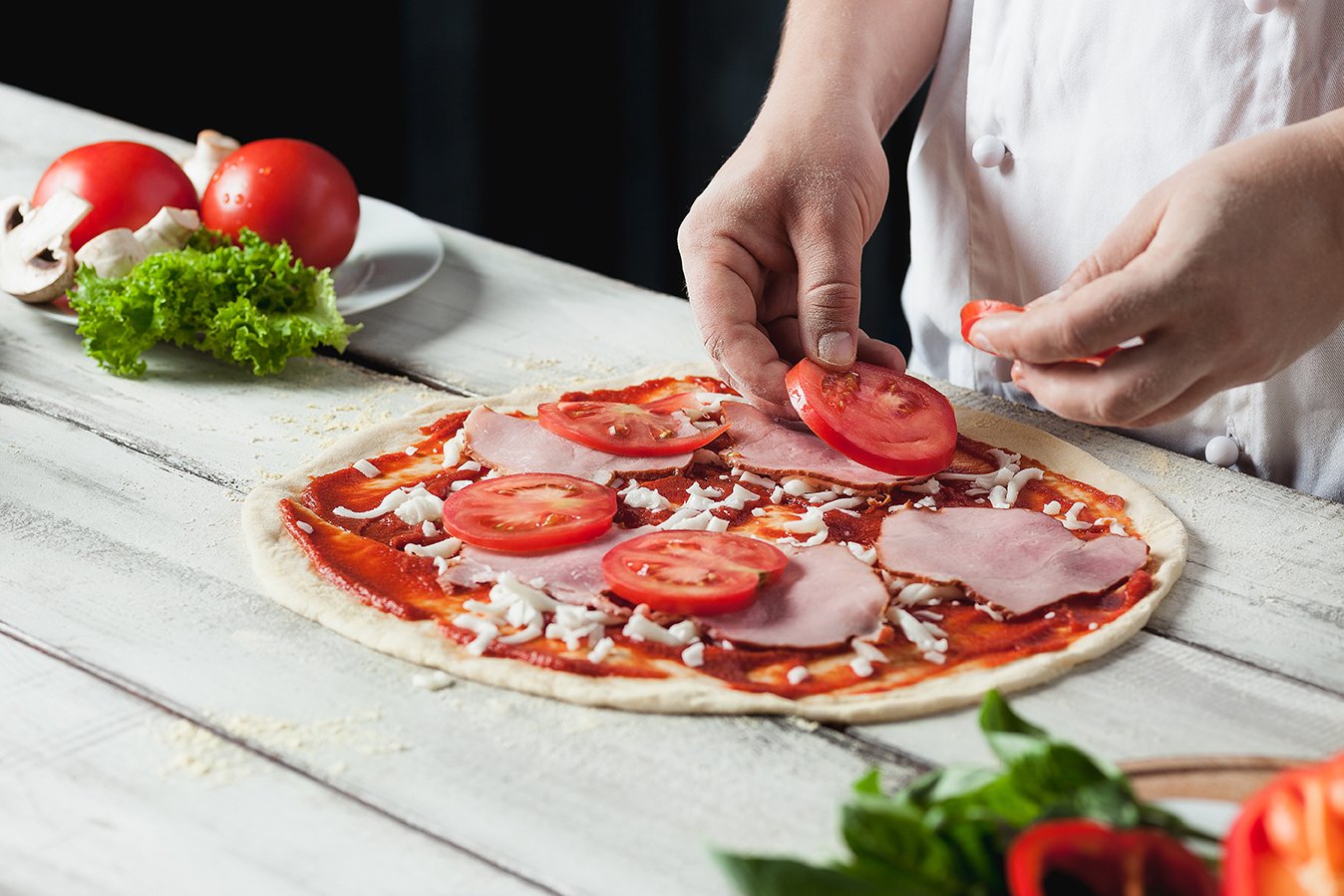 closeup-hand-chef-baker-white-uniform-making-pizza-kitchen